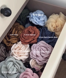 Detail view of 9cm fabric rose hair claws in various elegant colors inside a drawer