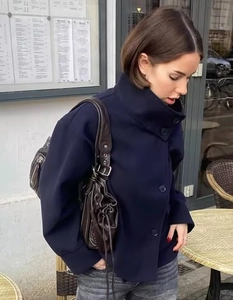 Streetstyle-Ansicht des marineblauen Kurzmantels mit Stehkragen und brauner Ledertasche