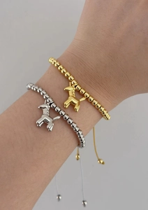 Detail view of adjustable gold and silver beaded bracelets with unicorn animal pendants