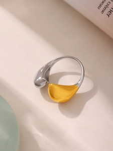 Macro detail of tear-drop style open ring in high-polish gold and silver contrast finish