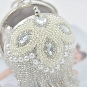 Close-up of sphere evening bag with inlaid pearls, crystals and luxury diamond tassels