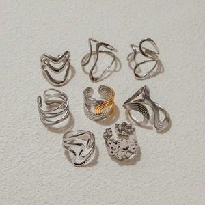 Detailed view of eight silver irregular geometric rings with lava textures and wavy lines