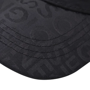 Close-up of black baseball cap visor featuring detailed embossed letter texture