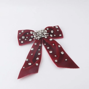 Detail of red velvet bow hairclip with sparkling silver rhinestones for women