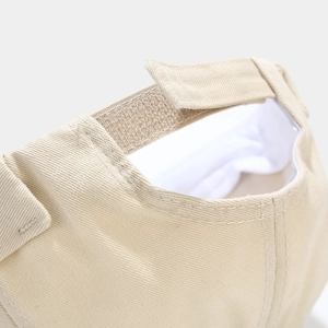 Detailed close-up of beige cotton docker cap with adjustable velcro strap closure