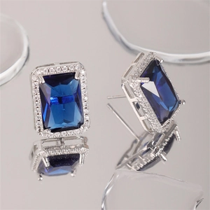 Macro shot of square blue zircon earrings with silver micro-pave diamond borders