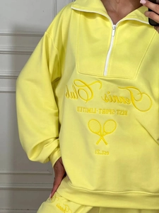 Bright yellow two-piece lounge set with half-zip hoodie and tennis club embroidery