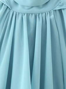 Detailed macro view of light blue pleated chiffon fabric texture and vertical folds