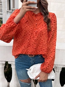 Detail of orange hollow out embroidered blouse with long sleeves and ruffled collar design