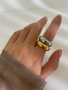 Nahaufnahme von hochglanzpolierten Gold- und Silber-Edelstahlringen an der Hand
