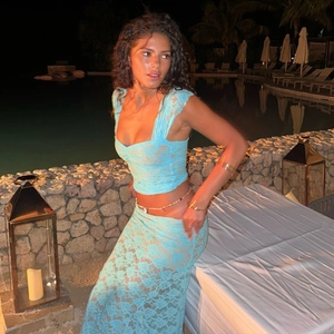 Élégant ensemble haut court en dentelle bleue et jupe longue au bord de la piscine