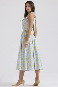 Detail view of a floral backless maxi dress with cross-tie straps in light blue and yellow