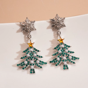 Close-up of snowflake and green rhinestone Christmas tree earrings with pearls