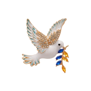 Elegant gold-tone peace dove brooch with white enamel feathers and colorful crystals