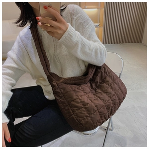 Sac hobo en nylon matelassé marron présenté sur un mannequin en situation