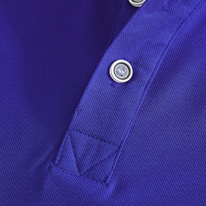 Macro detail of dark blue polo shirt collar featuring piqué texture and clear buttons