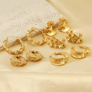 Detailed view of 18k gold plated earrings with zircon inlays and textured metal finishes