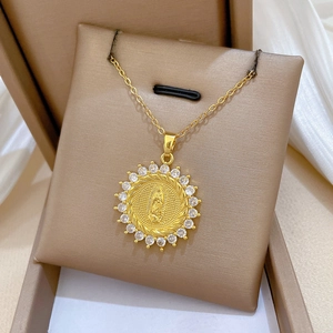 Detailed close-up of a gold Virgin Mary pendant necklace with sparkling crystal halo