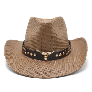 Detail of woven straw cowboy hat with leather band, gold studs and metal bull head logo