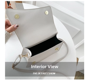 Interior view of small white crossbody bag showing black lining and gold magnetic closures