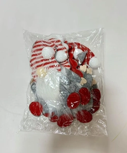 Macro view of Christmas gnome cutlery holder set with red striped hats in packaging
