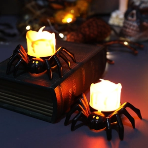 Halloween decorative spider LED candle light with warm flame on vintage book background