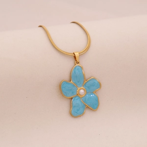 Detail of gold snake chain with blue floral enamel pendant and center pearl accent