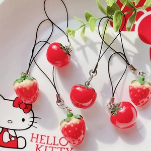 Artistic layout of strawberry and tomato pendants in a ceramic plate with greenery