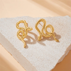 Elegant gold-plated stainless steel snake earrings displayed on a white textured stone