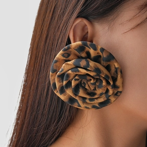 Macro side view of model wearing large fabric leopard print rose flower stud earrings