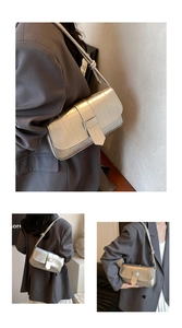 Detail of silver crocodile pattern shoulder bag with a unique knot strap design