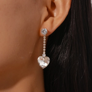 Detail of silver heart tassel earrings with sparkling zircon crystals on a model