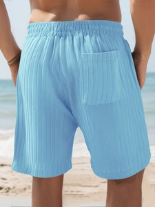 Rear view of men's light blue striped knit shorts at the beach with back pocket