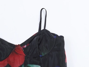 Détail du tissu organza avec fleurs rouges et fines bretelles réglables noires