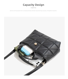 Detail view showing internal capacity of black quilted shoulder bag with gold clasp