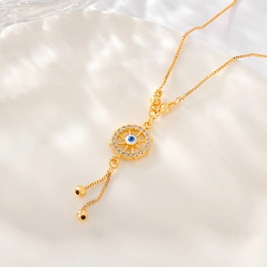 Macro shot of gold necklace with blue evil eye pendant and adjustable slider chain