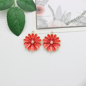Detailed macro view of red enamel daisy pendants with golden alloy edges for DIY jewelry