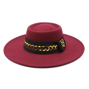 Detail of burgundy wide brim wool felt hat with decorative black band and gold chain link