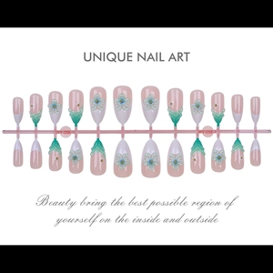 Close-up of 3D floral press-on nails with pink base, green petals and gold beads