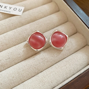 Macro shot of pink square stud earrings with resin stones in a soft velvet jewelry box