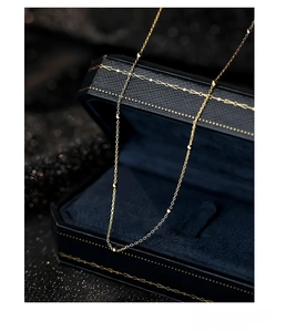Macro shot of S925 silver gold bead necklace on luxury navy velvet jewelry box