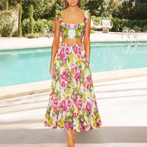 Detailed shot of high-waist floral long skirt and crop top set by the blue poolside