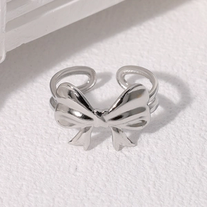 Macro shot of silver bow ring featuring a polished mirror finish and adjustable open band