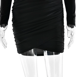 Détail de la robe noire à manches longues avec fronces élégantes et ourlet asymétrique