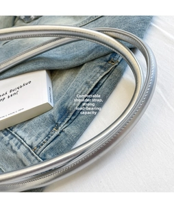 Close-up of comfortable silver padded shoulder strap with reinforced stitching on a bag