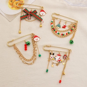 Detail of Christmas enamel pins with reindeer and Santa charms on golden chains