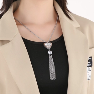 Close-up of silver long tassel necklace with crystal triangle pendant on model