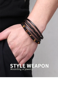 Detail of men's layered leather bracelet featuring tiger eye stone beads on a male wrist
