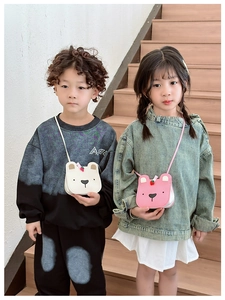 Detail of cute bear-shaped leather crossbody bags in white and pink for kids with straps