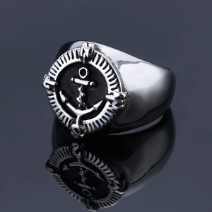 Macro shot of stainless steel anchor compass ring with N S E W engraving and reflection